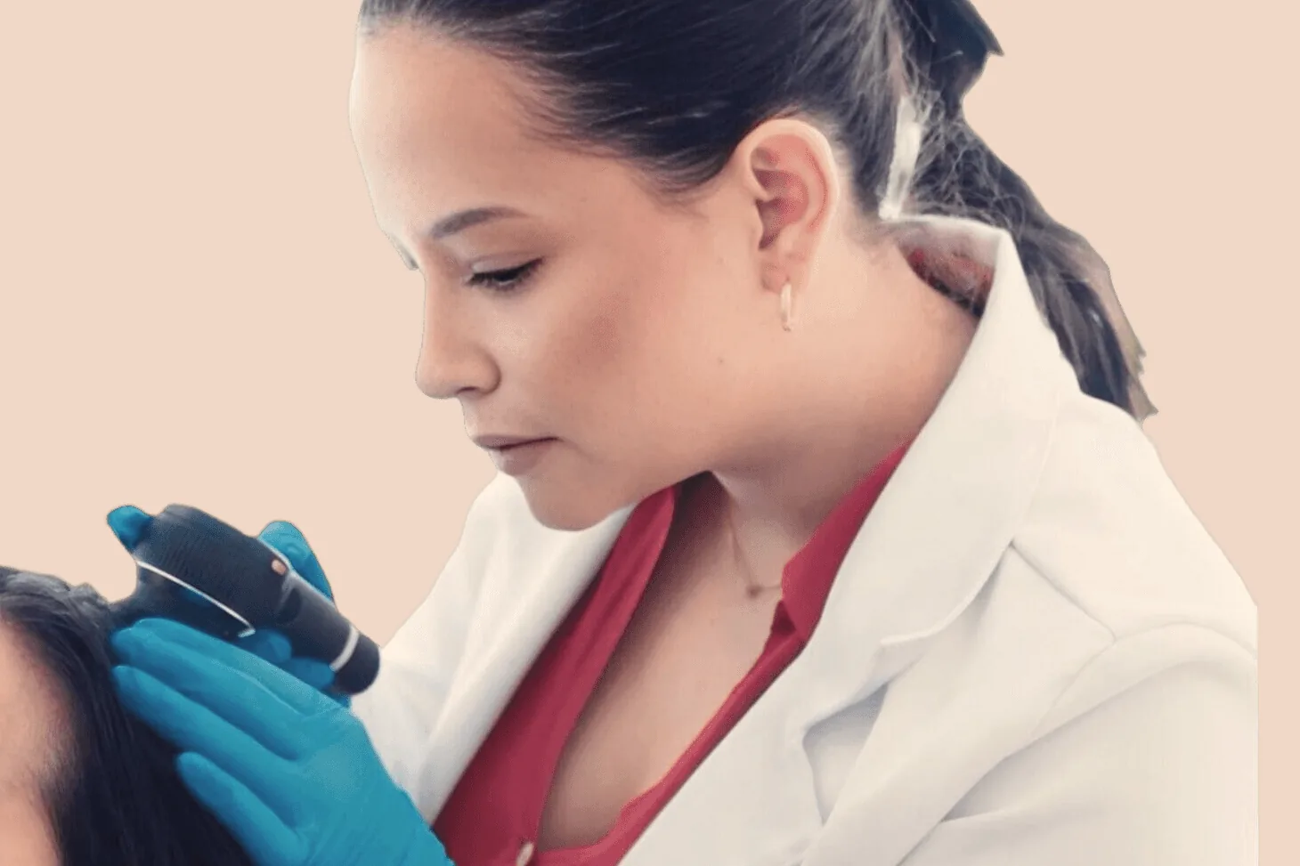 Dermatologist examining a patient with a dermatoscope at Clínica QARA